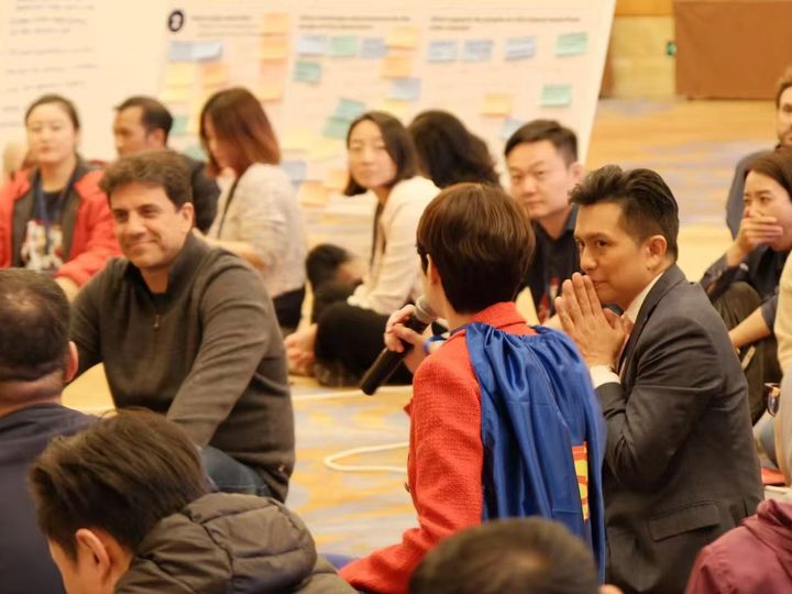 A group of participants sharing ideas on the floor during a team workshop